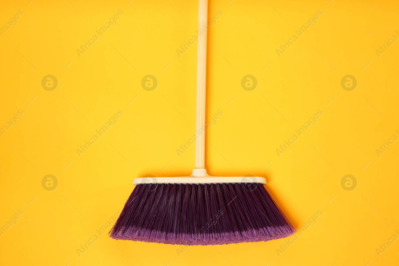 Photo of One cleaning broom on orange background, top view