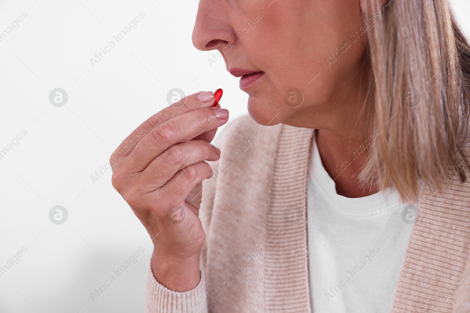 Photo of Senior woman taking pill at home, closeup