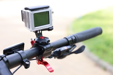 Modern action camera with mount on bicycle outdoors, closeup