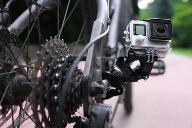 Modern action camera with mount on bicycle outdoors, closeup