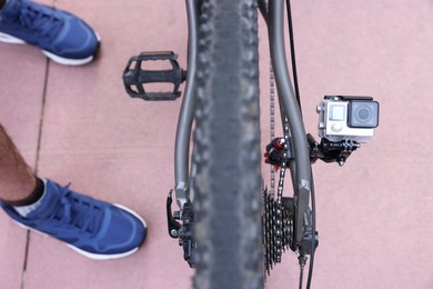 Man near bicycle with modern action camera outdoors, closeup