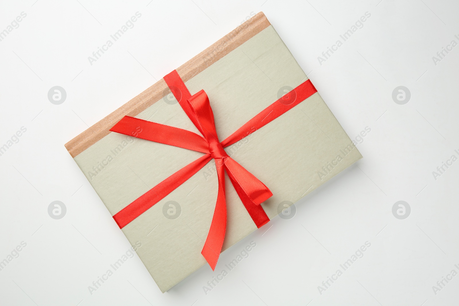 Photo of Book tied with red ribbon on white background, top view