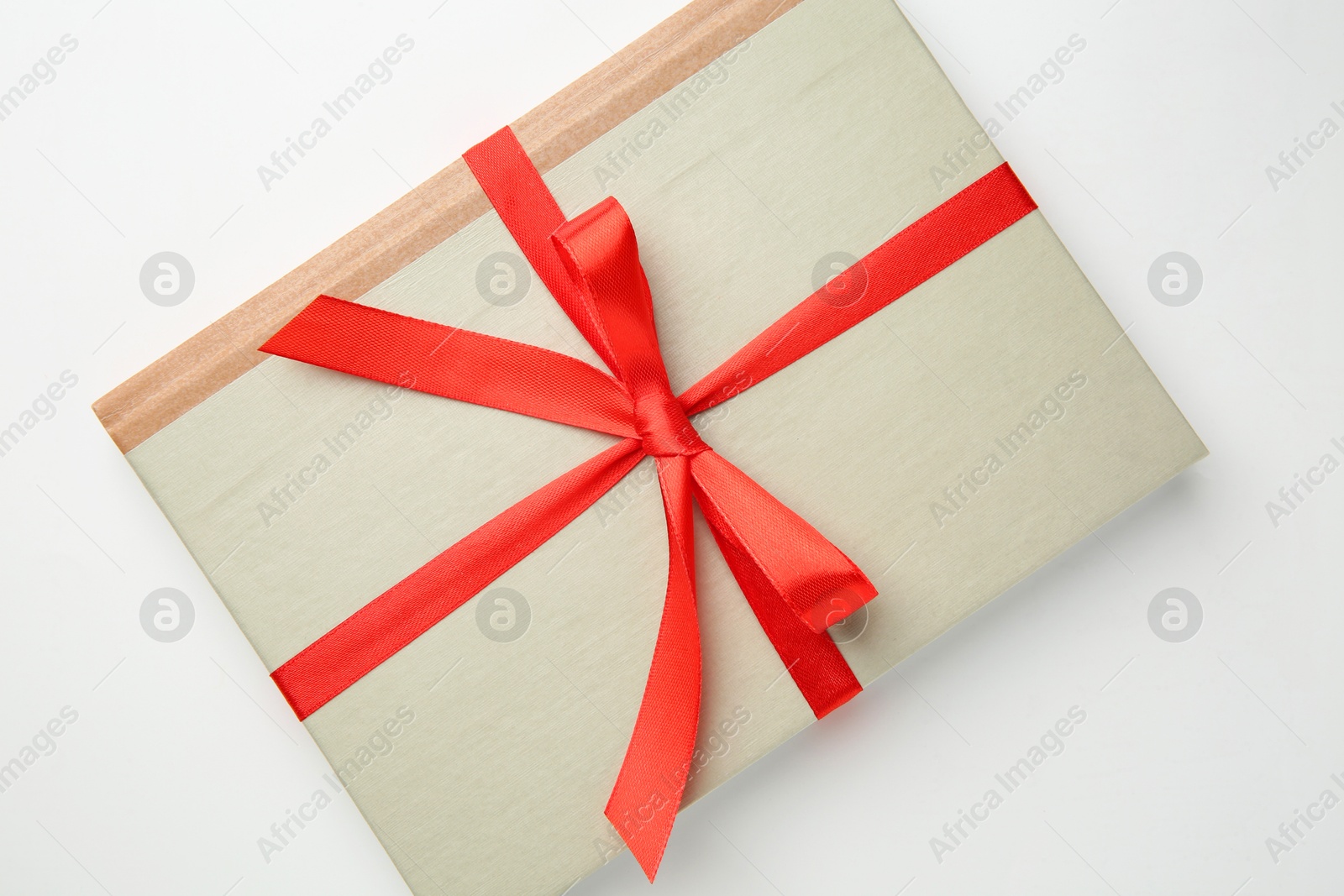 Photo of Book tied with red ribbon on white background, top view