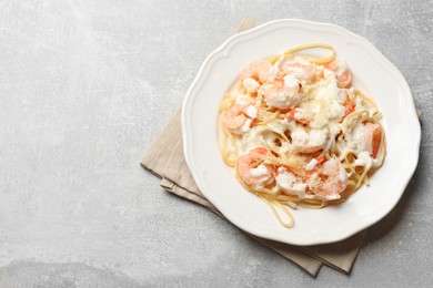 Delicious pasta with shrimps on light table, top view. Space for text