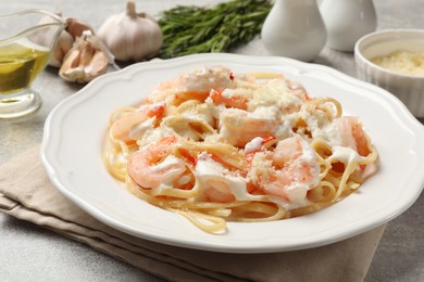 Photo of Delicious pasta with shrimps served on light table, closeup