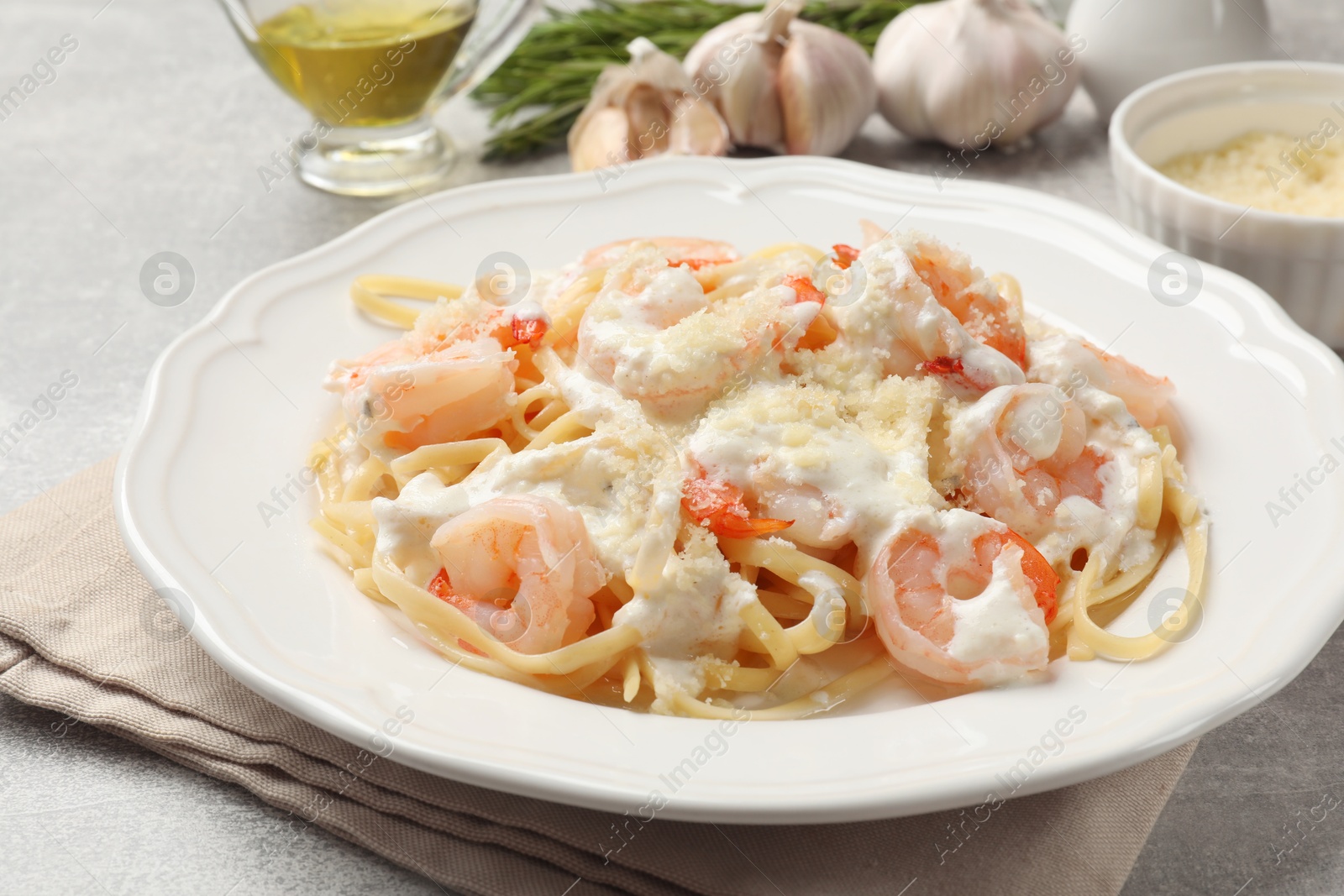 Photo of Delicious pasta with shrimps served on light table, closeup