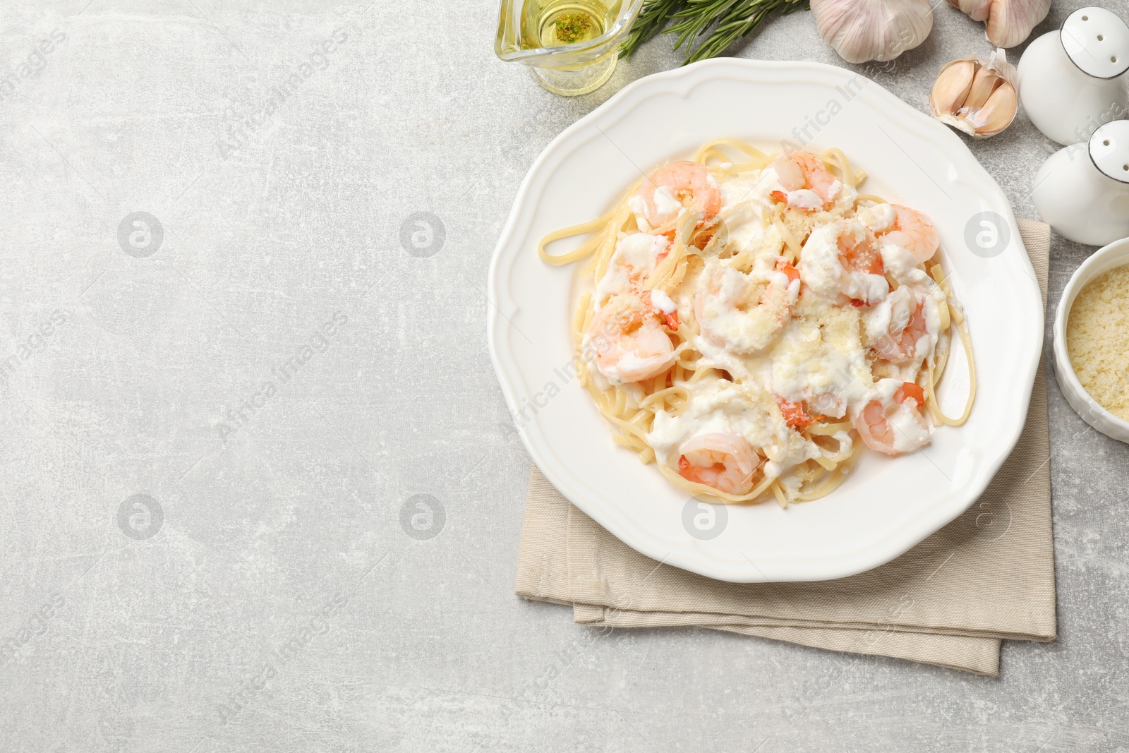 Photo of Delicious pasta with shrimps served on light table, flat lay. Space for text