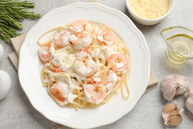 Photo of Delicious pasta with shrimps served on light table, flat lay