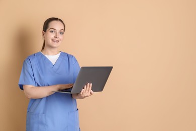 Photo of Professional nurse working with laptop on dark beige background. Space for text