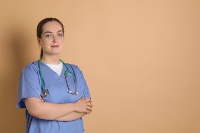 Portrait of professional nurse with stethoscope on dark beige background. Space for text