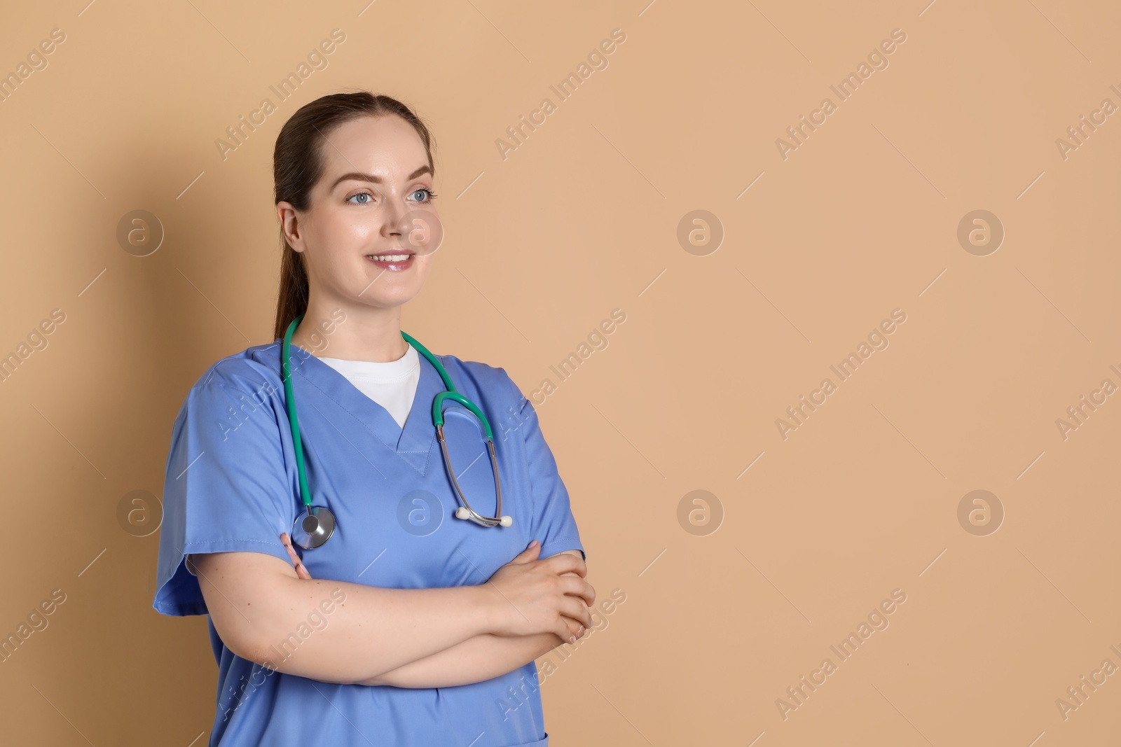 Photo of Portrait of professional nurse with stethoscope on dark beige background. Space for text