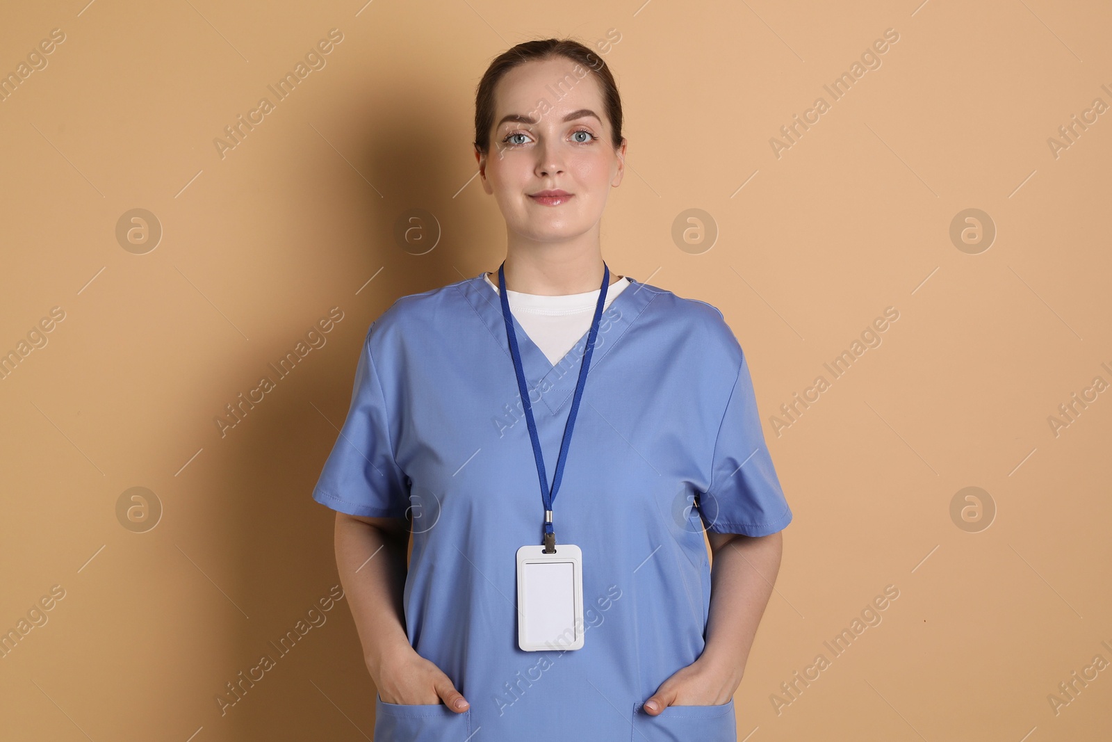 Photo of Professional nurse with badge on dark beige background