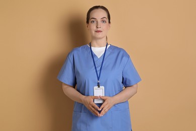 Professional nurse with badge on dark beige background