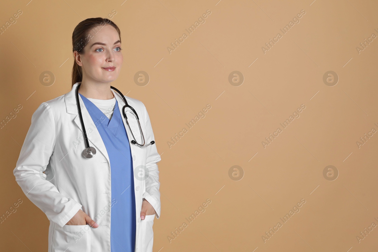 Photo of Portrait of professional nurse on dark beige background. Space for text