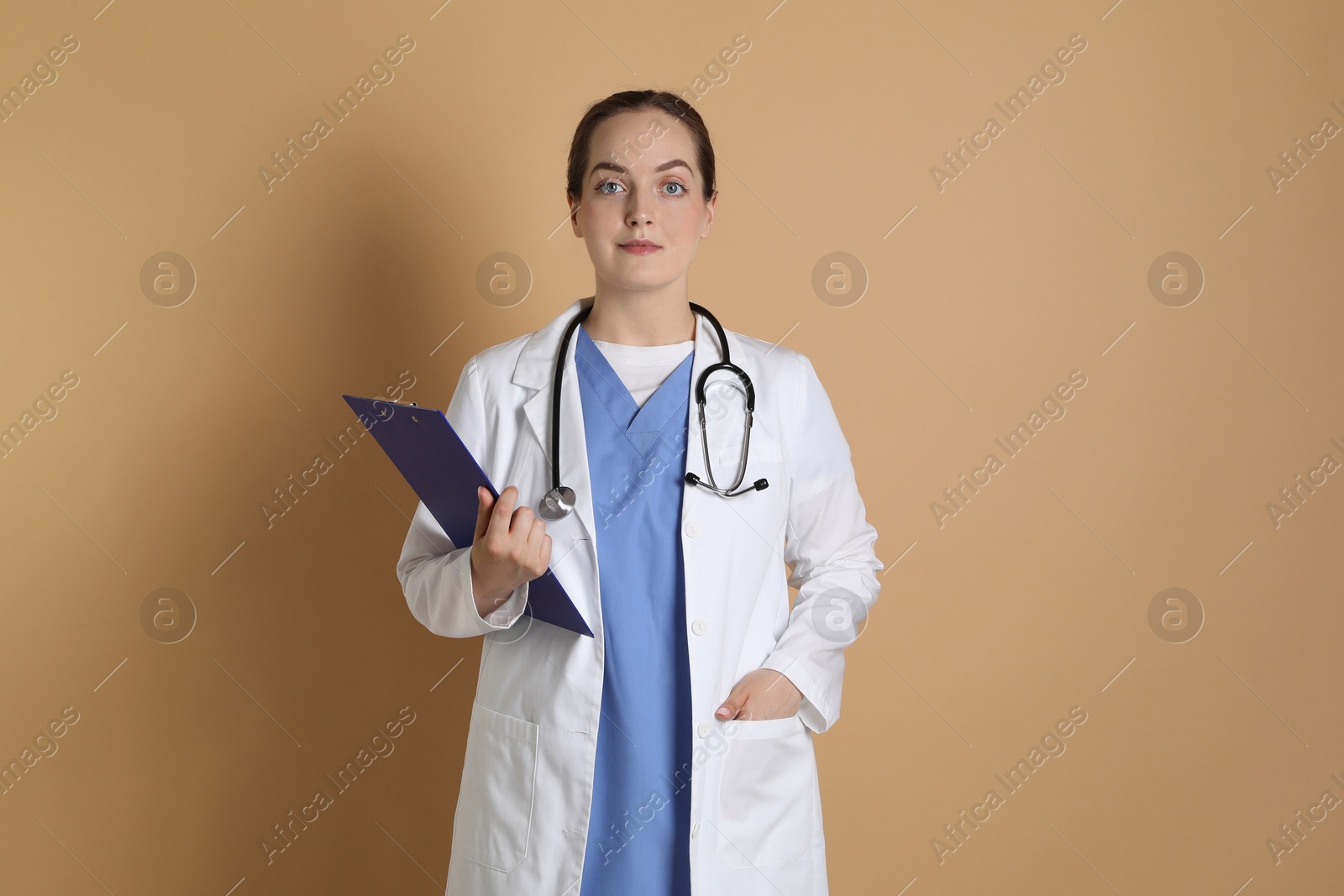 Photo of Portrait of professional nurse with clipboard on dark beige background