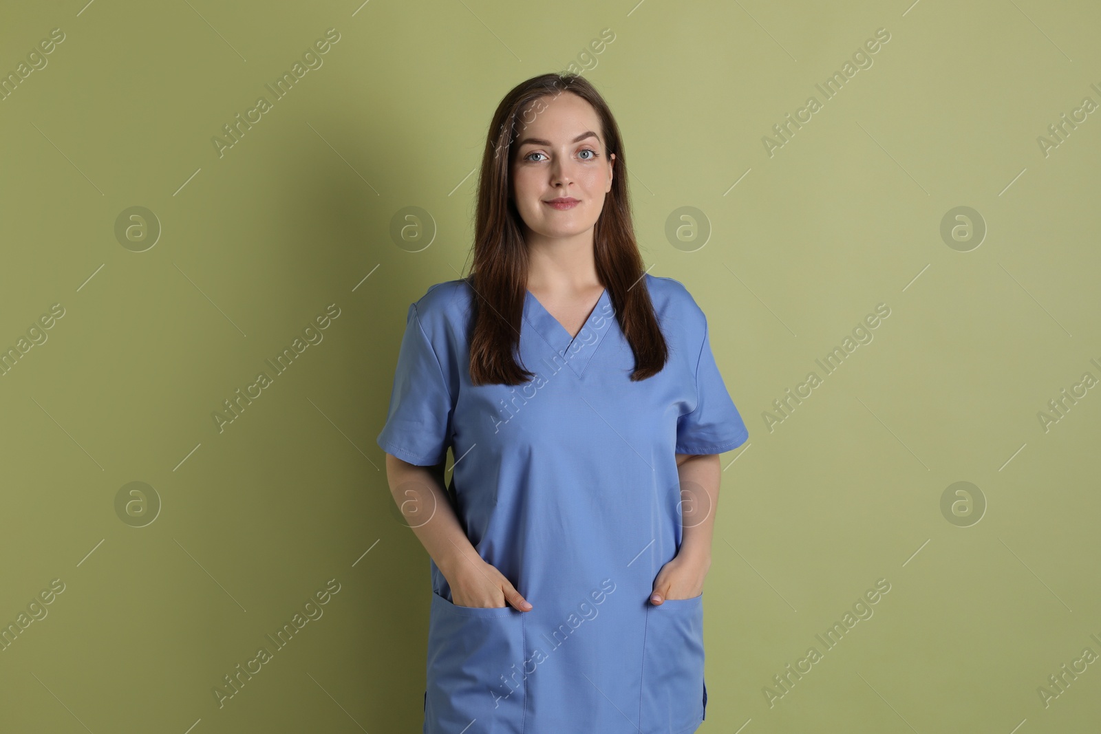 Photo of Professional nurse in uniform on pale green background