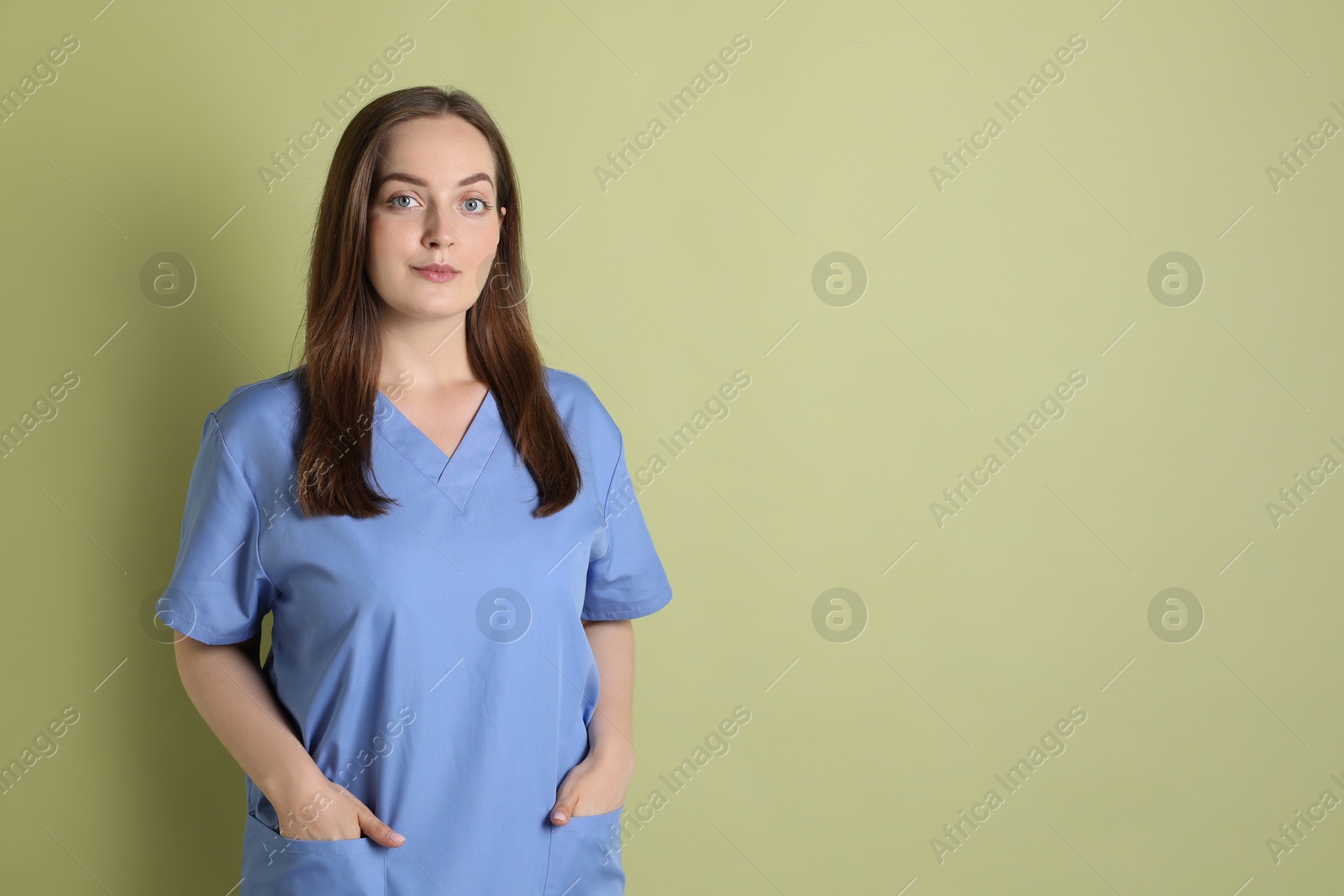 Photo of Professional nurse in uniform on pale green background. Space for text