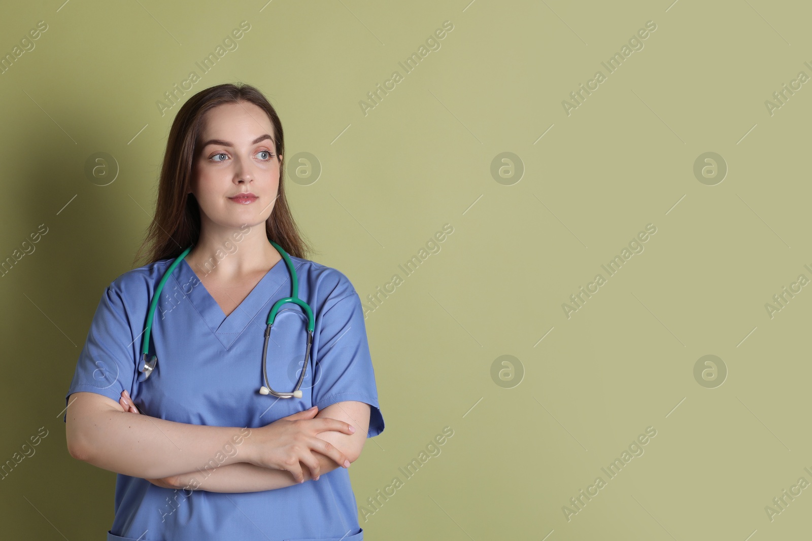 Photo of Professional nurse with stethoscope on pale green background. Space for text