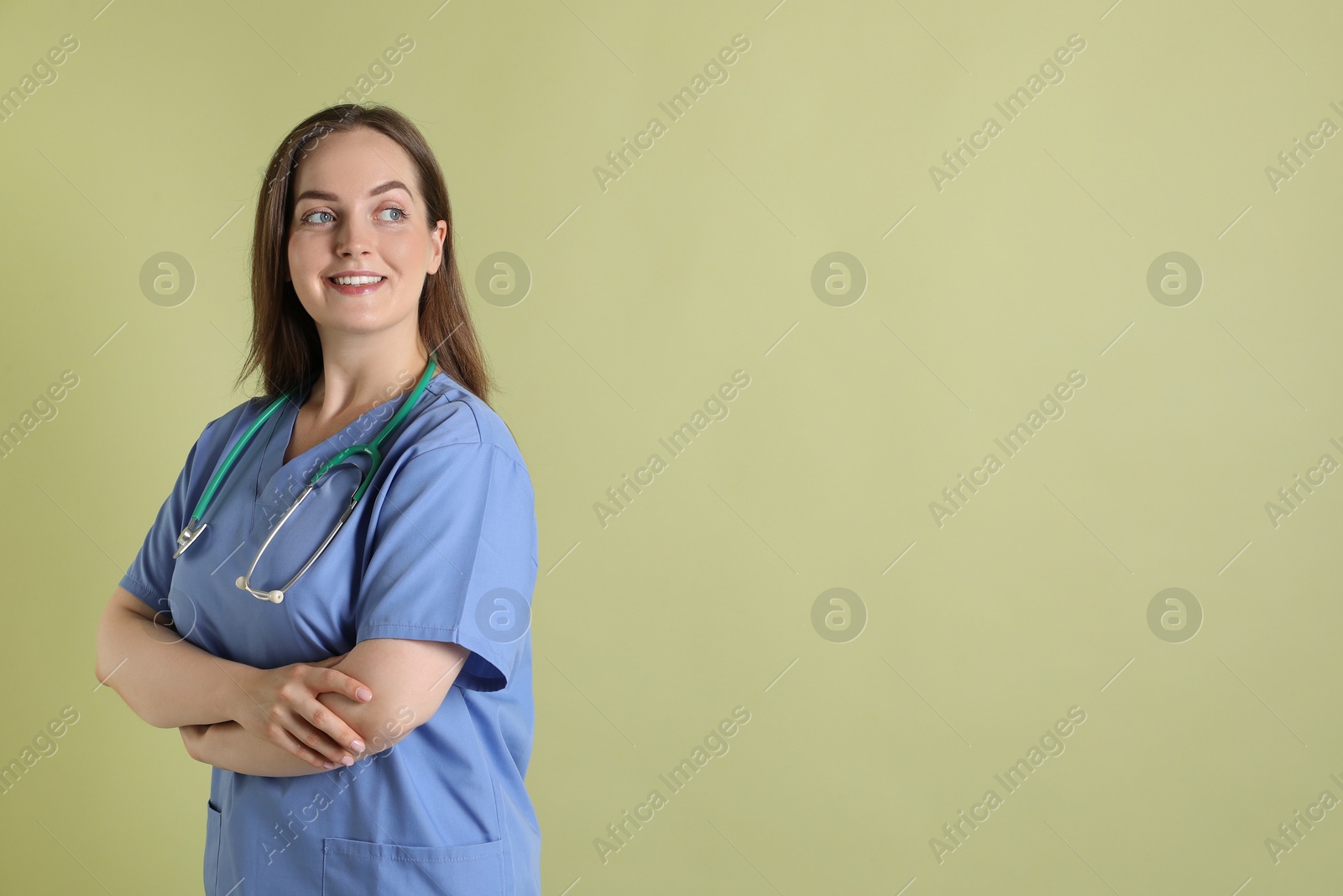 Photo of Professional nurse with stethoscope on pale green background. Space for text