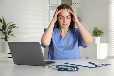 Tired nurse working at desk in hospital