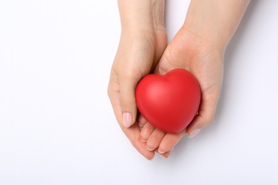 Photo of Woman with red decorative heart at white table, top view. Space for text