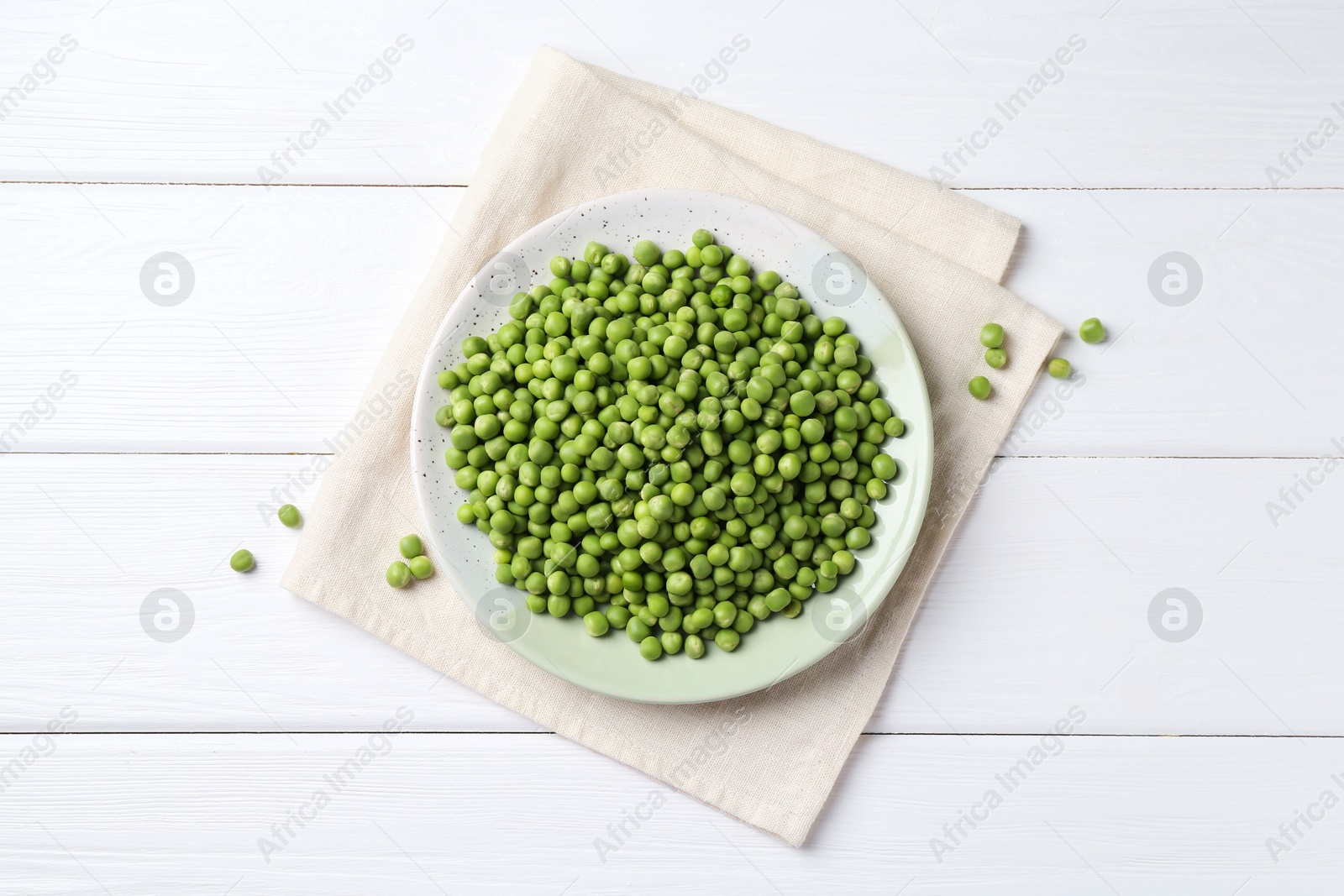 Photo of Fresh green peas on white wooden table, top view