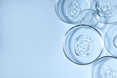 Photo of Petri dishes with samples on light blue background, top view. Space for text