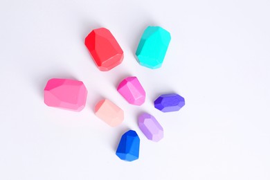 Photo of Many colorful balancing stones on white background, flat lay