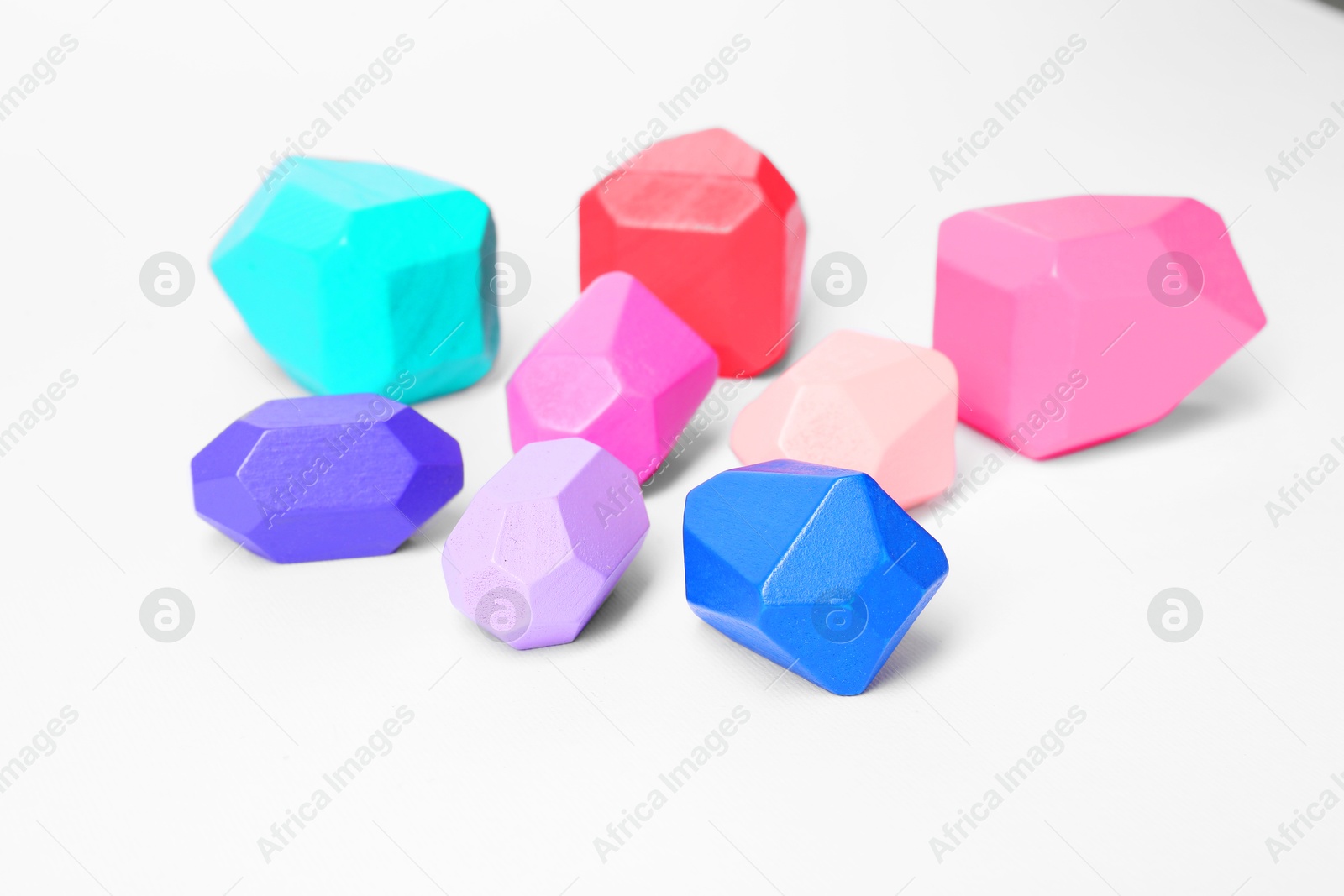 Photo of Many colorful balancing stones on white background