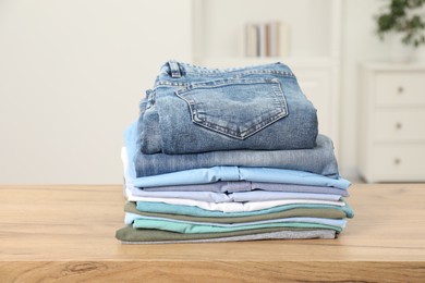 Photo of Stack of clothes on wooden table indoors