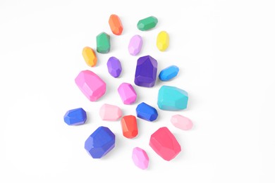 Photo of Many colorful balancing stones on white background, top view