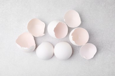 Photo of Broken eggshells on grey textured table, top view