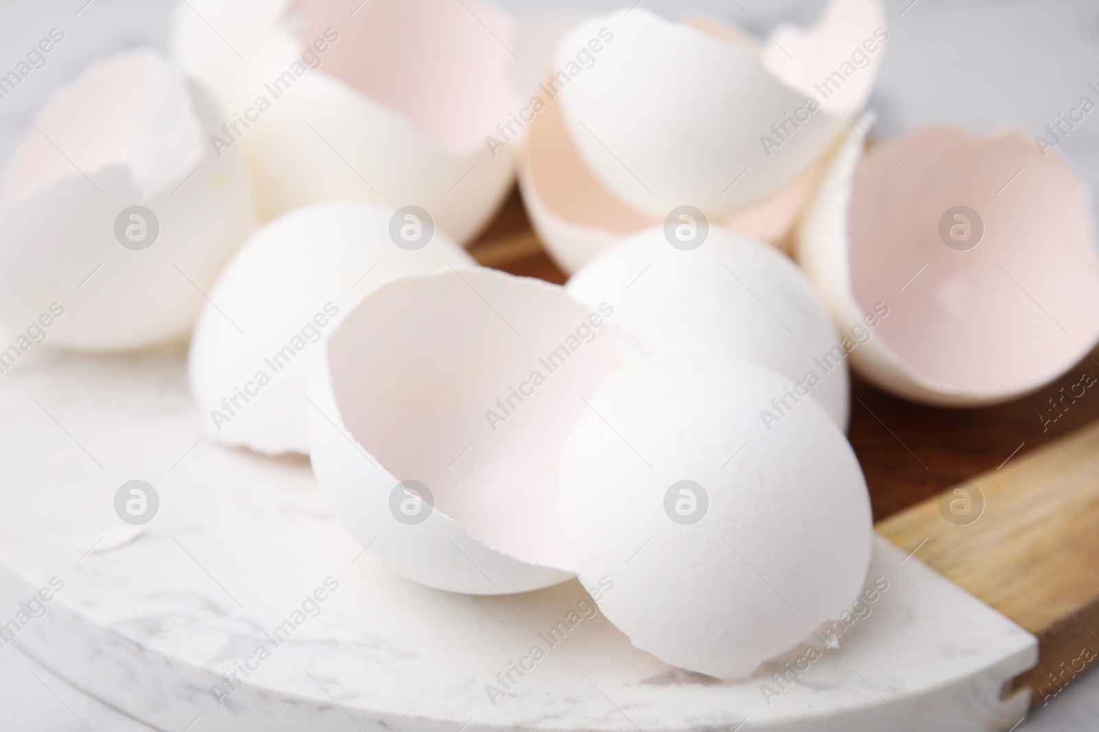 Photo of Pile of broken eggshells on board, closeup