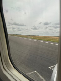 Photo of View on runway and surroundings through plane window