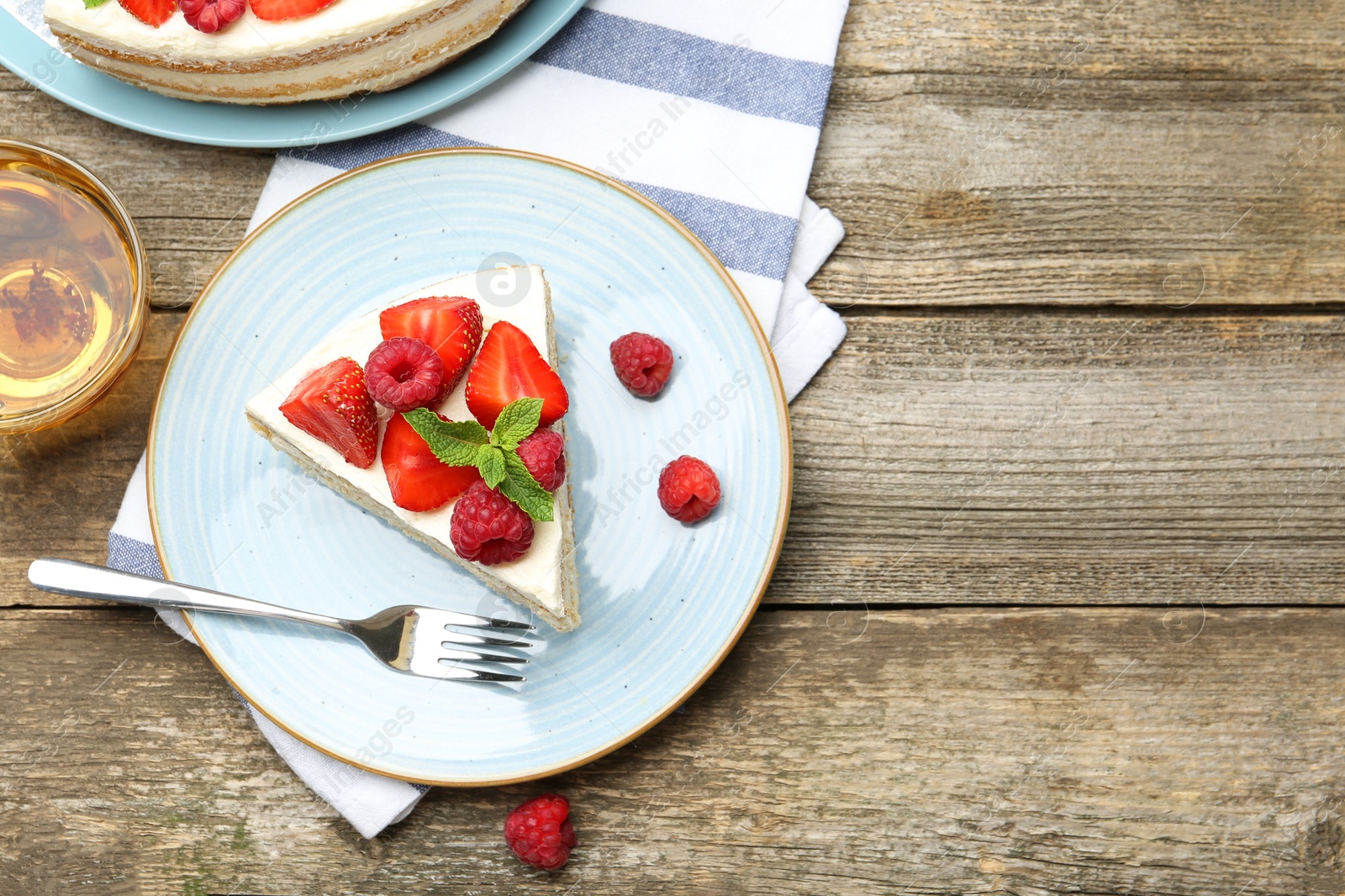 Photo of Tasty sponge cake with fresh berries and mint served on wooden table, flat lay. Space for text