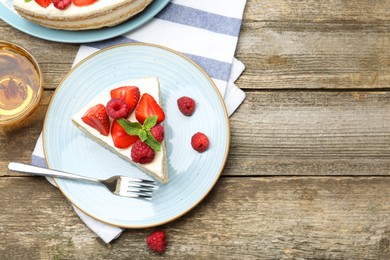 Photo of Tasty sponge cake with fresh berries and mint served on wooden table, flat lay. Space for text