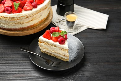 Photo of Tasty sponge cake with fresh berries and mint served on black wooden table