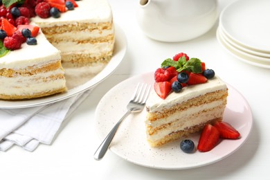 Photo of Tasty sponge cake with fresh berries and mint served on white table