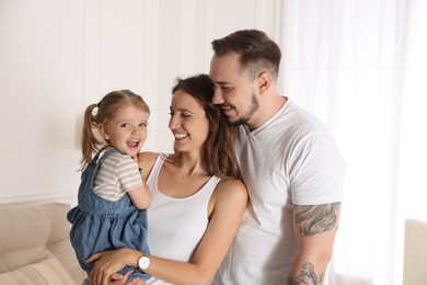 Happy family. Parents and their cute little daughter at home