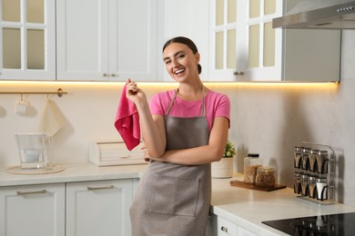 Beautiful young woman with rag in kitchen. Cleaning room