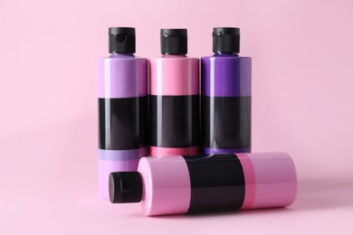 Photo of Acrylic paints of different colors on pink background