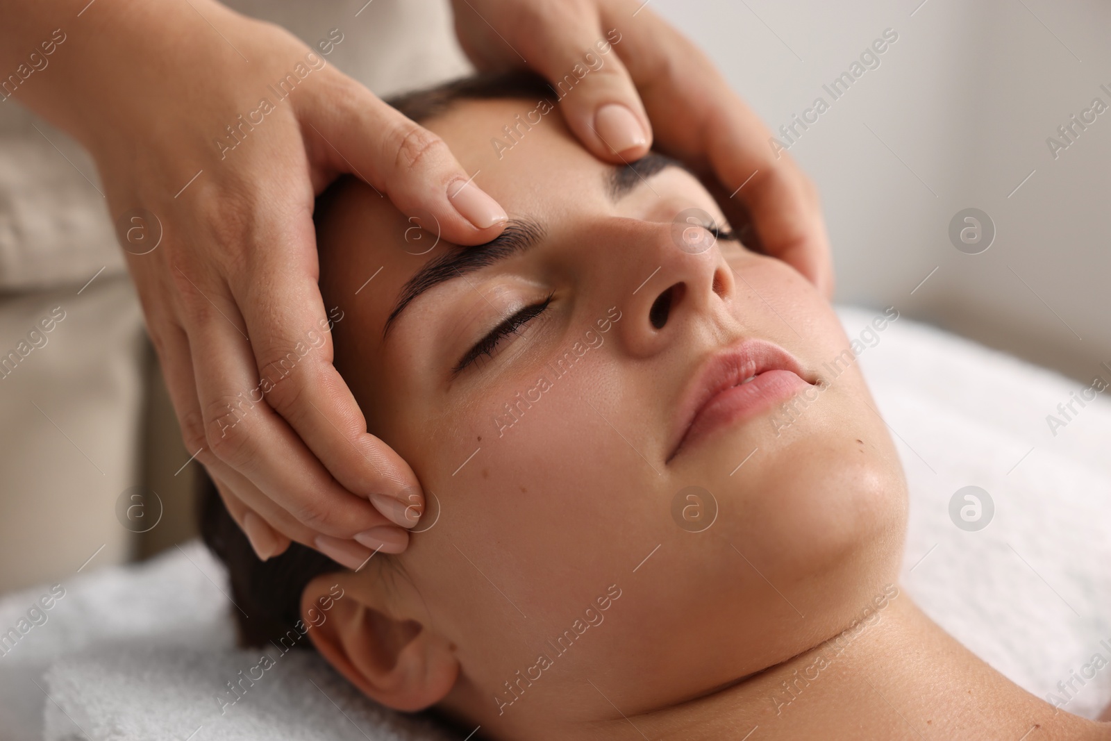 Photo of Attractive woman enjoying face massage, closeup. Beauty procedure