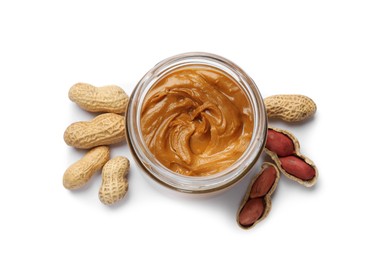 Photo of Tasty peanut butter in bowl and groundnuts isolated on white, top view