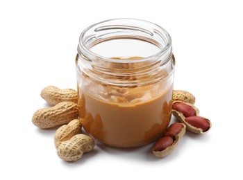 Photo of Tasty peanut butter in jar and groundnuts isolated on white