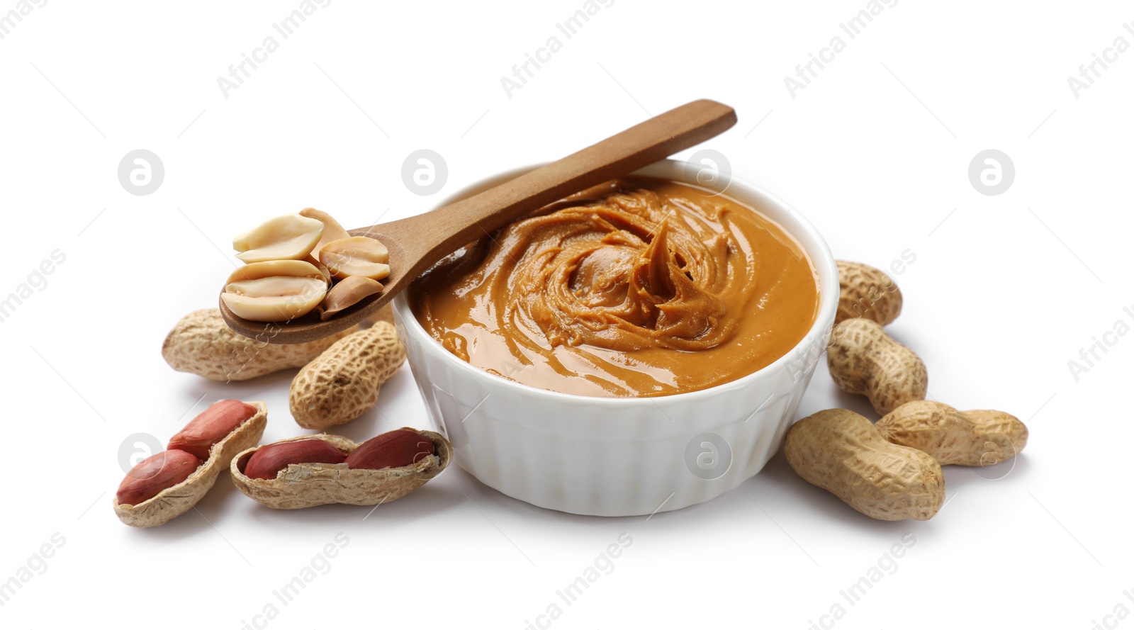 Photo of Tasty peanut butter in bowl, spoon and groundnuts isolated on white