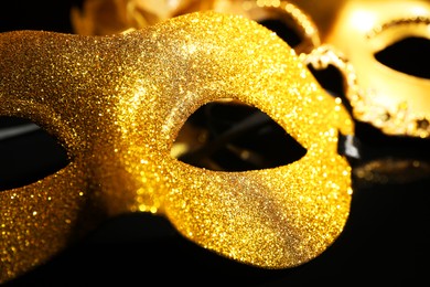 Beautiful golden carnival masks on black background, closeup