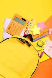 Photo of Backpack and different school stationery on color background, flat lay