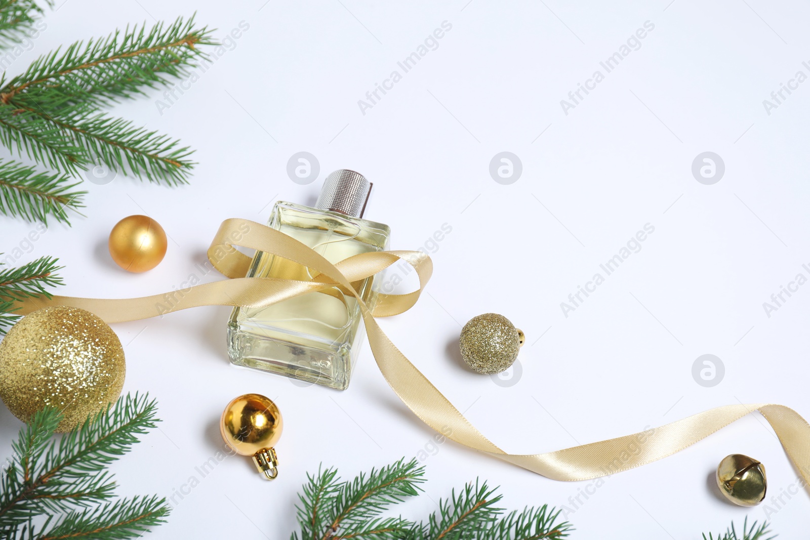 Photo of Christmas composition with perfume bottle on white background, above view. Space for text