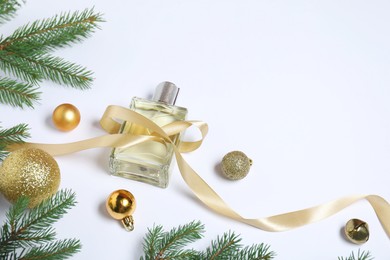 Christmas composition with perfume bottle on white background, above view. Space for text