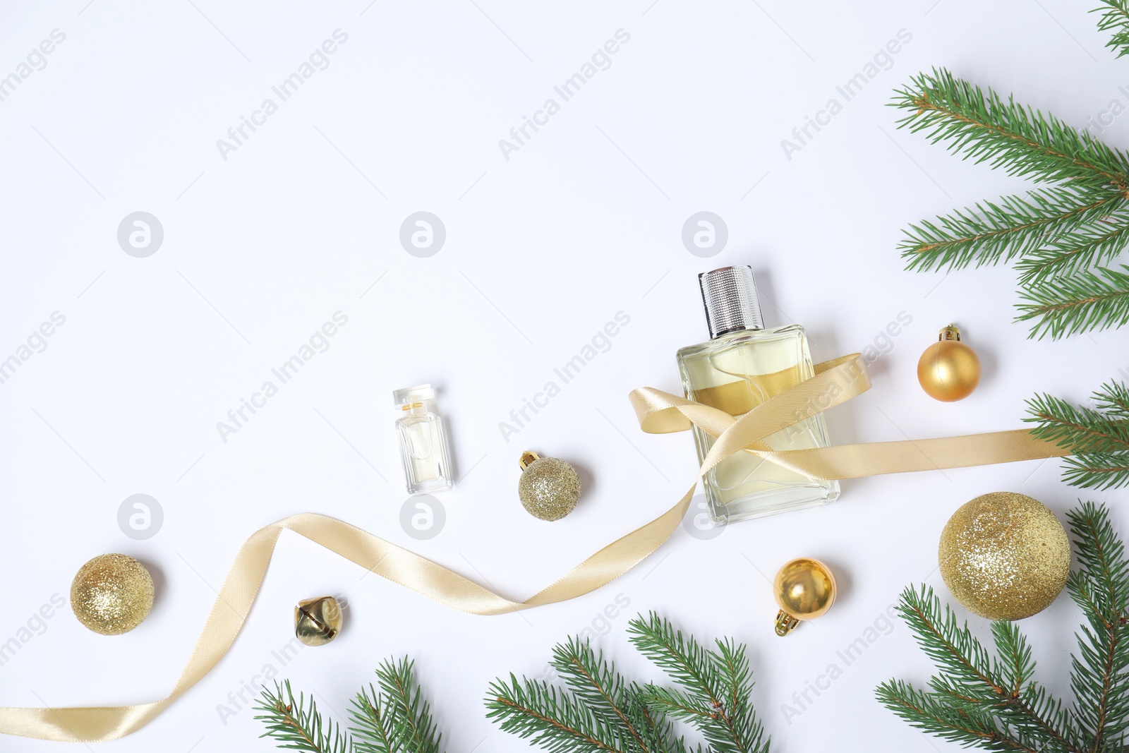 Photo of Christmas composition with perfume bottles on white background, flat lay. Space for text